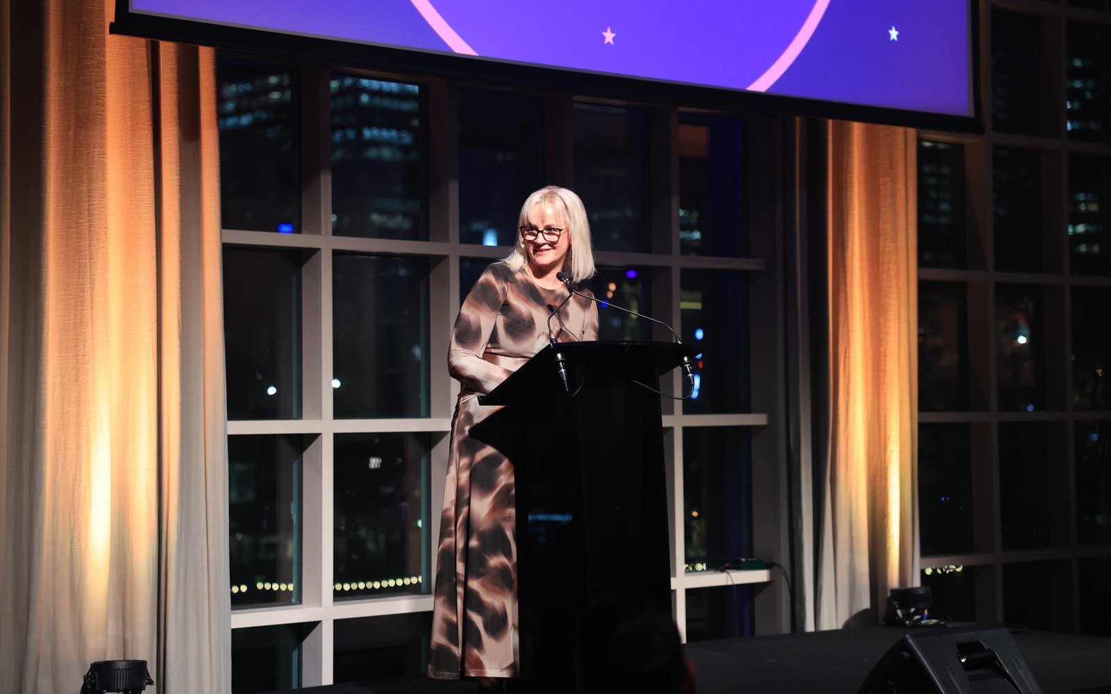Michelle Rose speaking at a lectern on stage