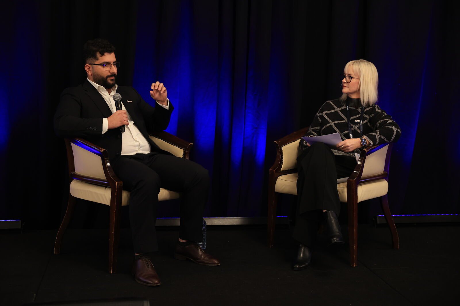Michelle Rose facilitating a panel discussion on stage